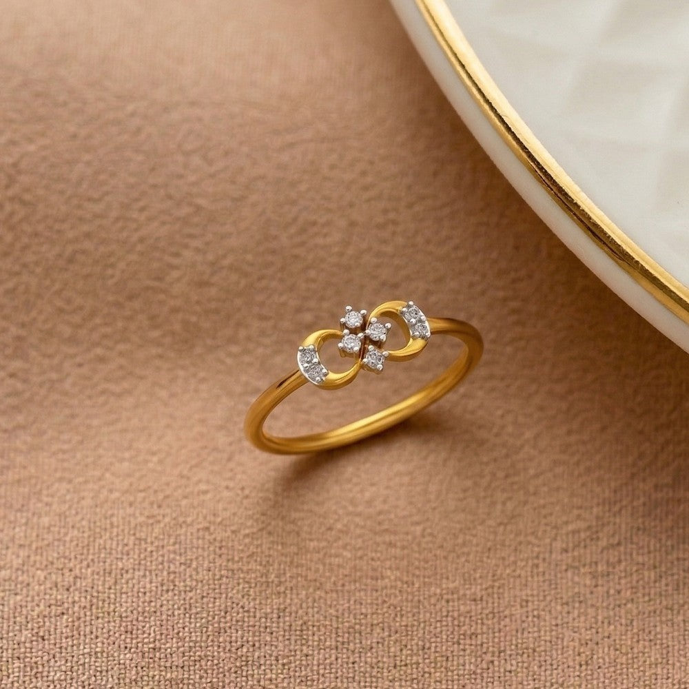 Gold ring with diamond accents on a beige surface