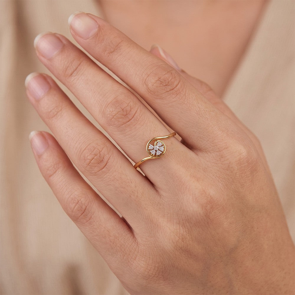 A close-up of a hand wearing a delicate gold and diamond ring.