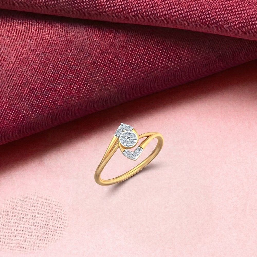 A gold ring with a cluster of round diamonds, displayed on a pink surface .