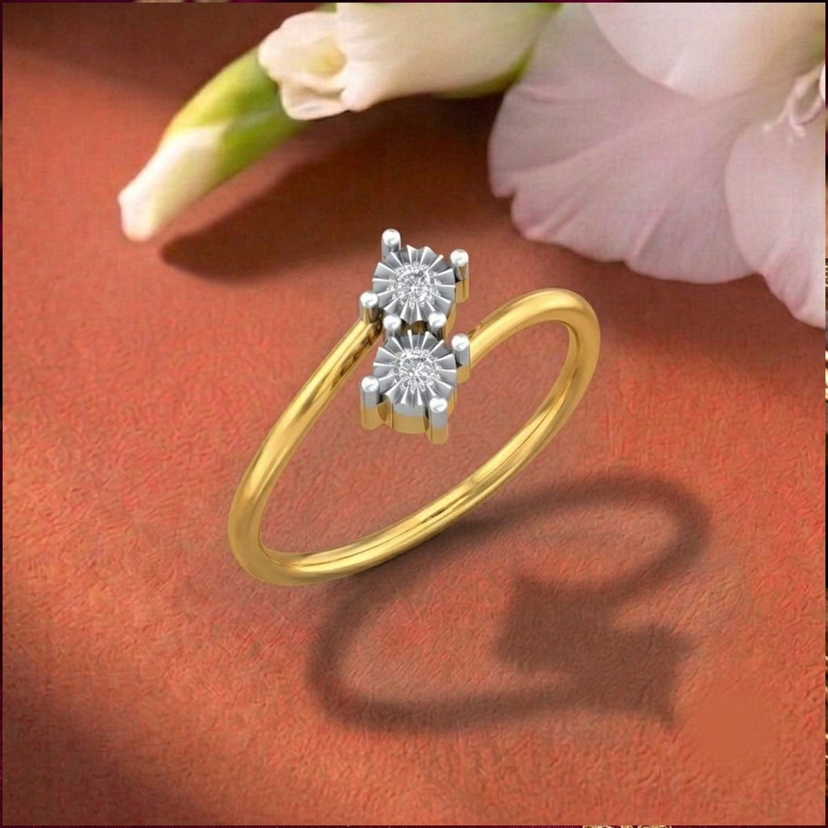 Gold ring with two diamonds on a orange surface