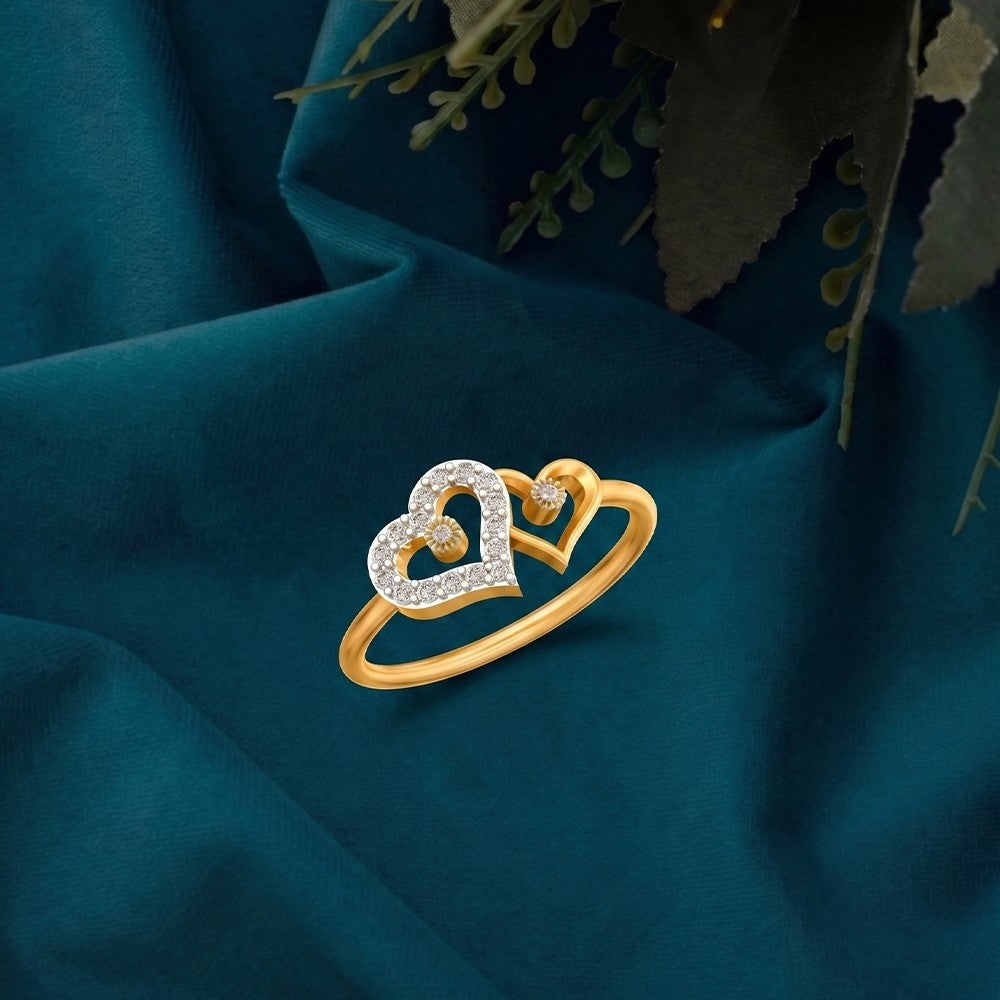 Gold and diamond with heart-shaped ring on a teal fabric surafce.