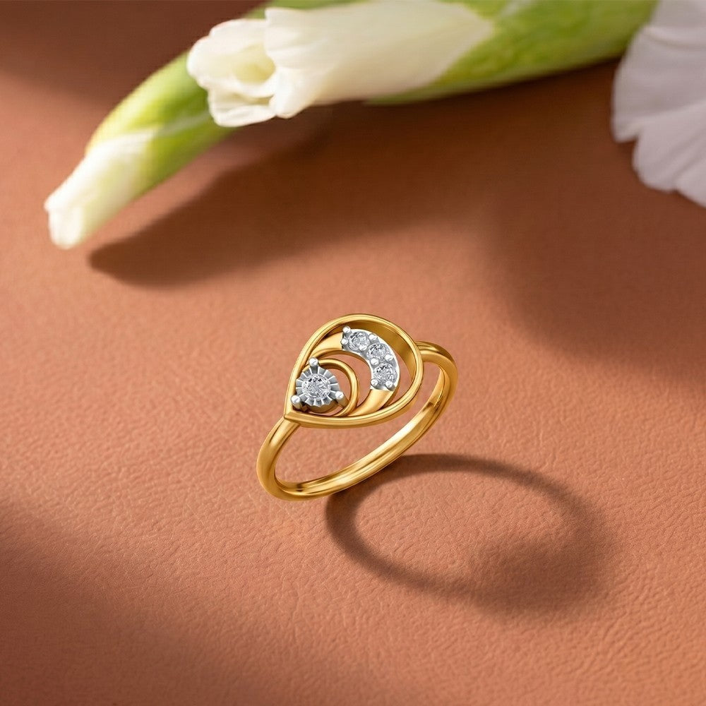 Gold ring with diamonds on a brown surface with a white flower