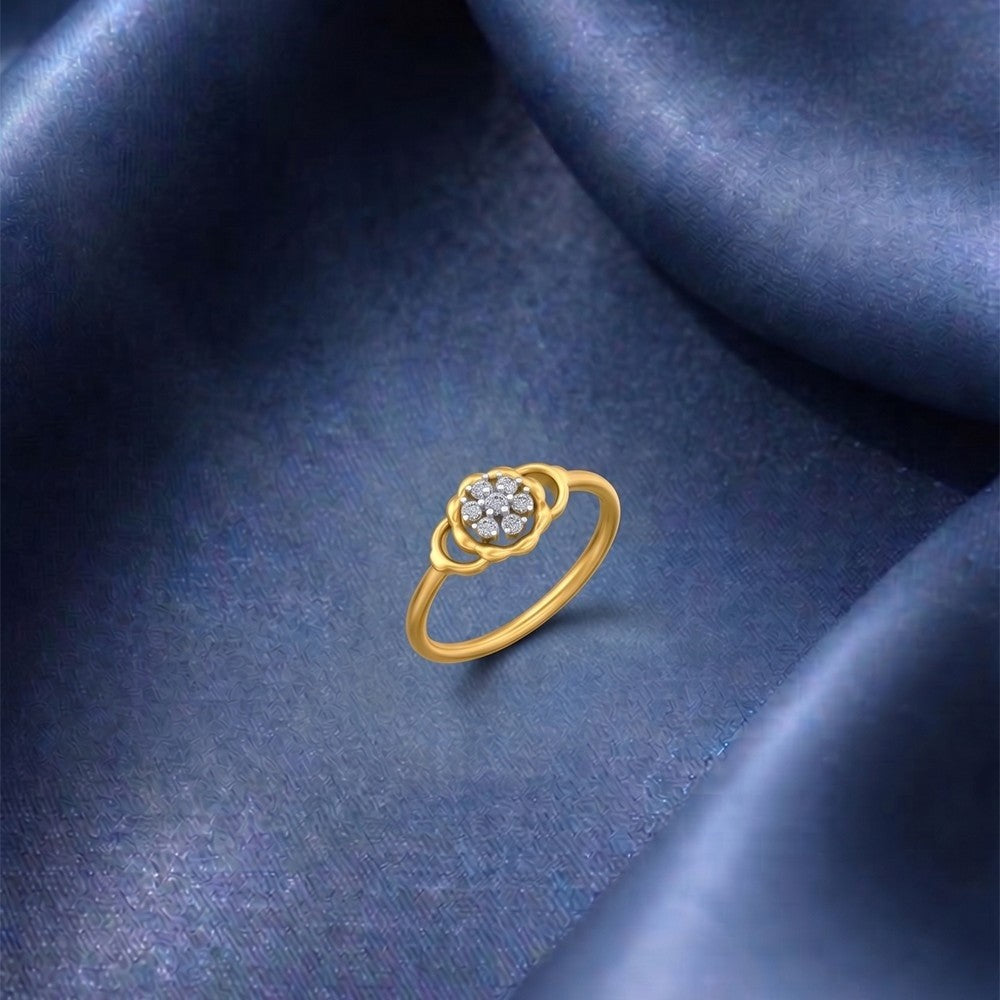 A gold ring featuring a central cluster, set against a blue fabric surface.