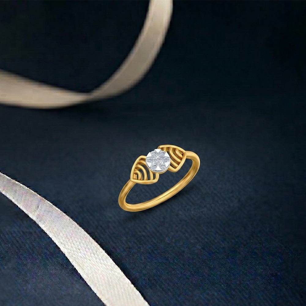Gold and diamond ring with a central cluster, set against a navy blue taxture surface.