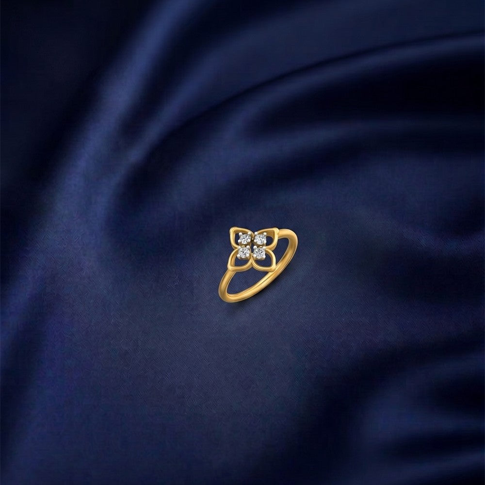 A gold and diamond ring with a floral design set, displayed on a dark navy blue satin fabric background.