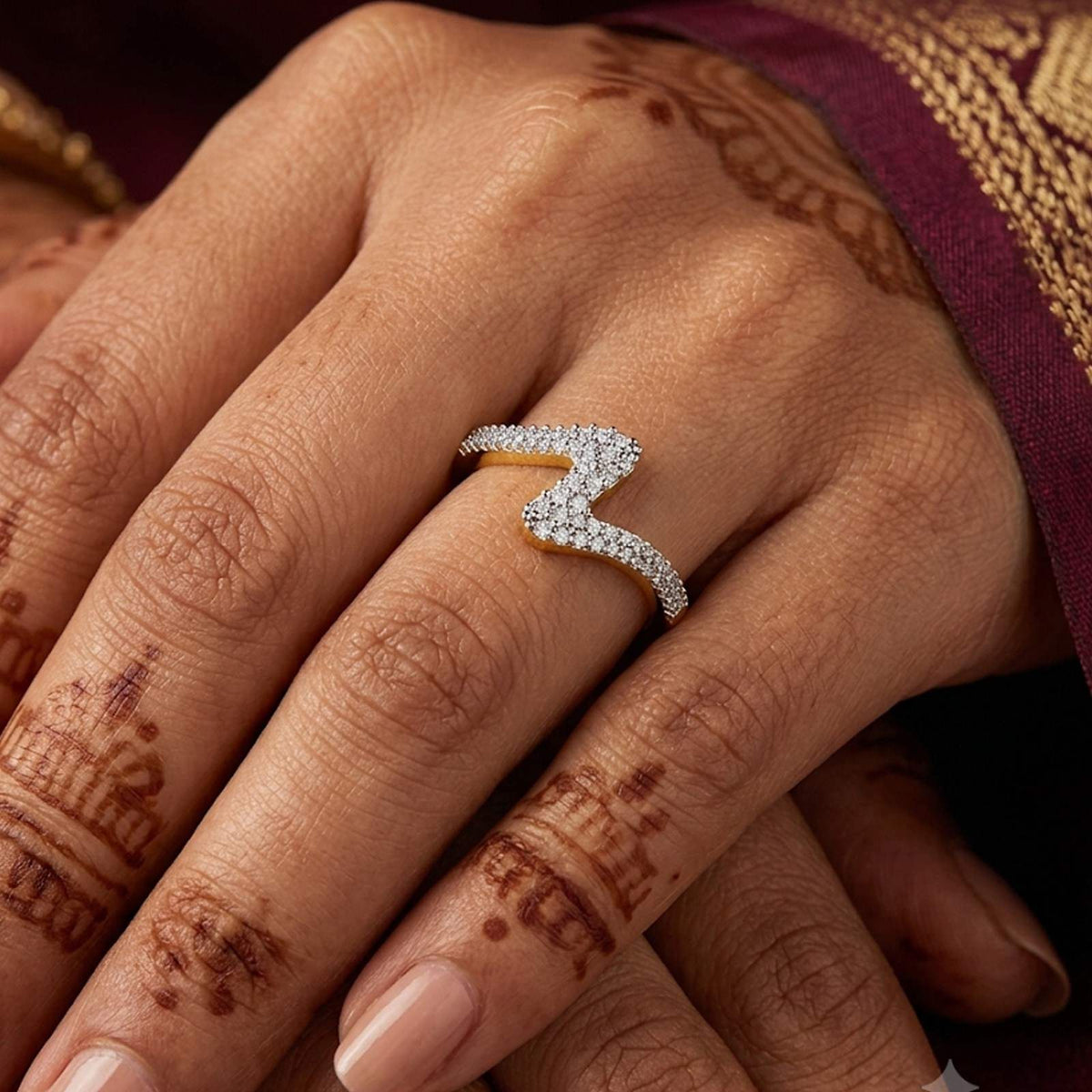 A close-up of a hand wearing a gold ring with a wavy.