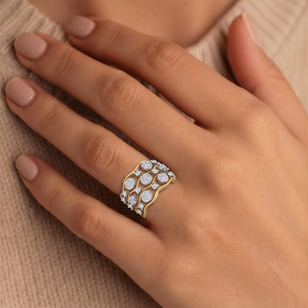 A close-up of a woman's hand wearing a gold ring with multiple rows of round, set against a soft beige.