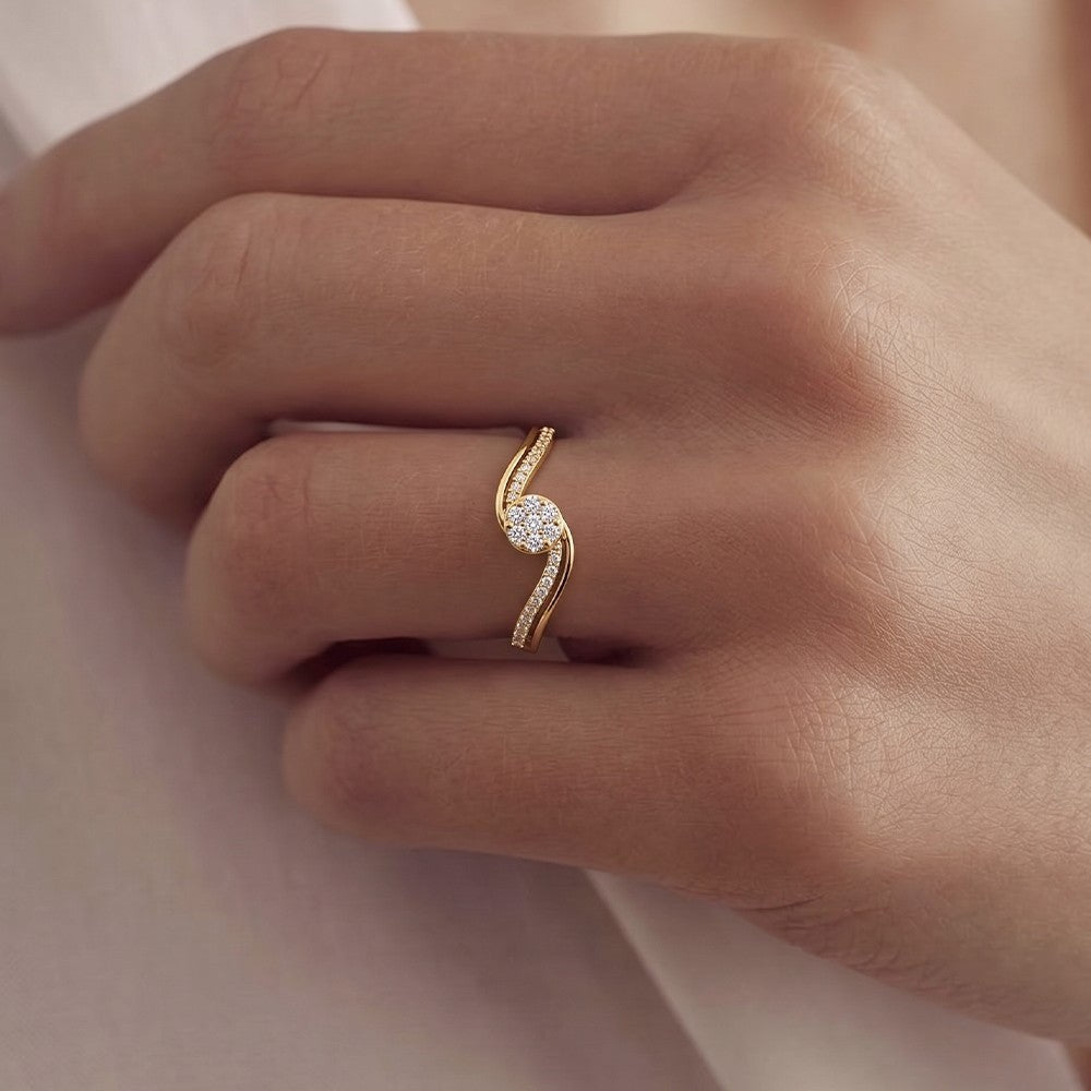 Gold ring with diamonds on a person's finger against a neutral background