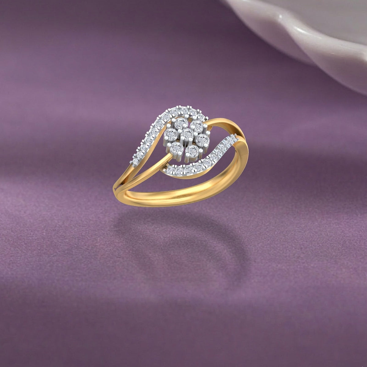 Gold and diamond ring with cluster accents on a purple fabric background.