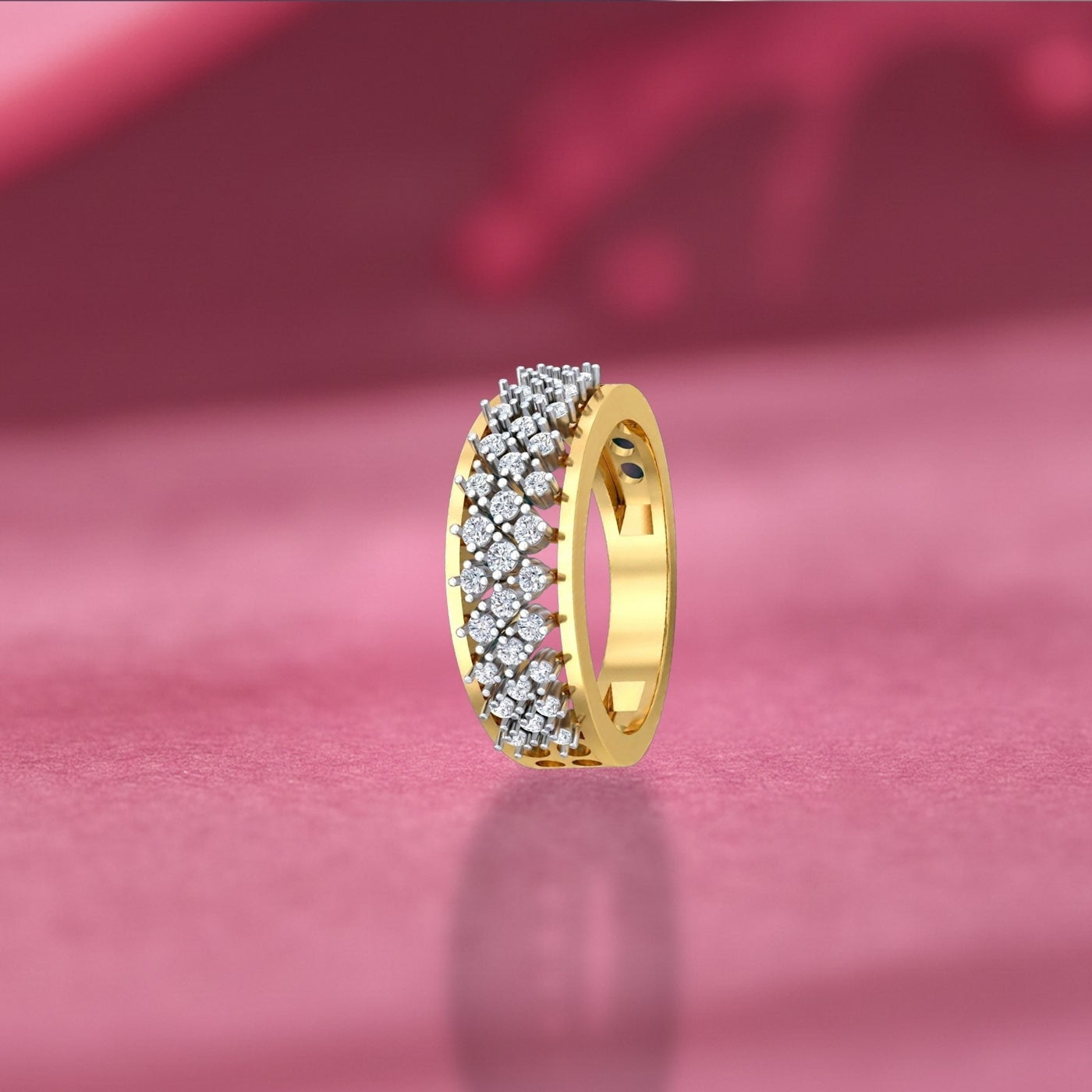 Gold ring with diamonds on a pink fabric background