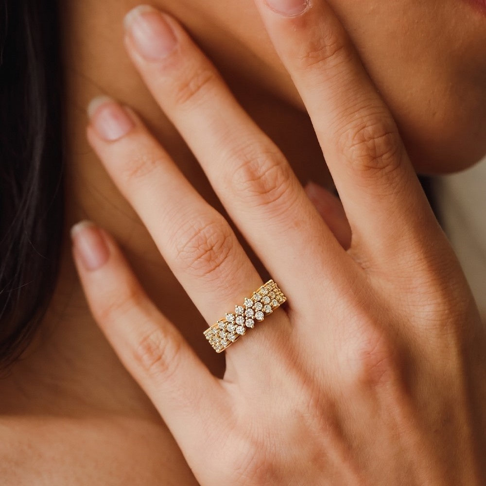 Close-up of a hand wearing a diamond ring with a blurred background