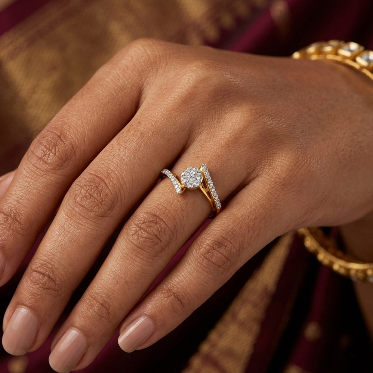 Hand wearing two gold rings with diamond accents on a red background