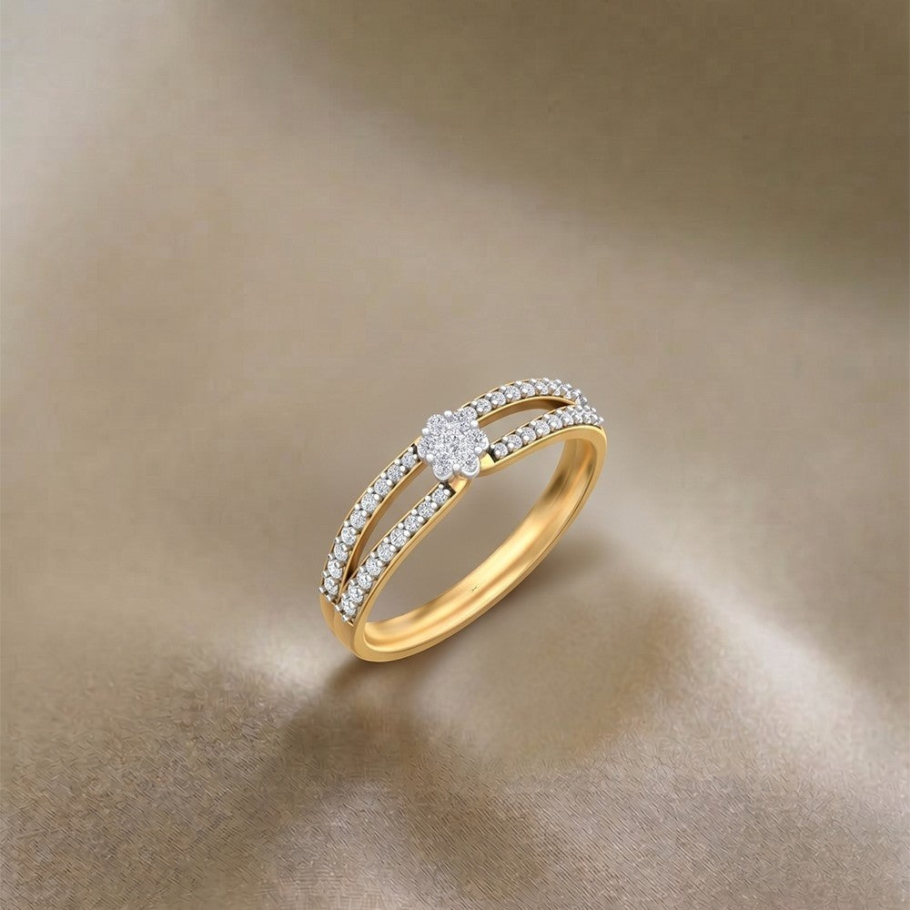 A gold ring with a central floral diamond and two curved rows, displayed on a soft beige satin background.