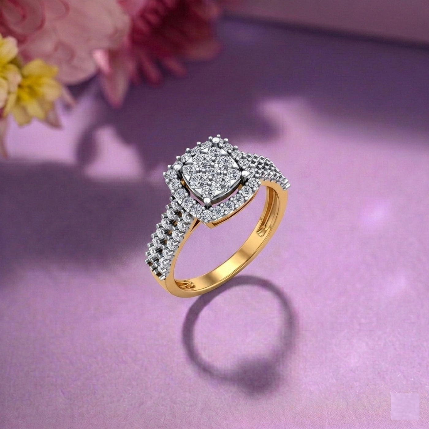 Gold and diamond ring on a pink surface with flowers in the background