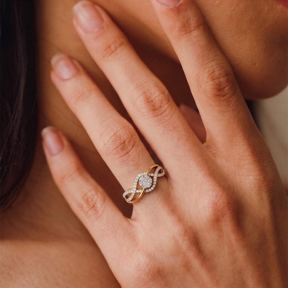 A close-up shot of a gold ring with a pavé-set round center, worn on a woman's finger.