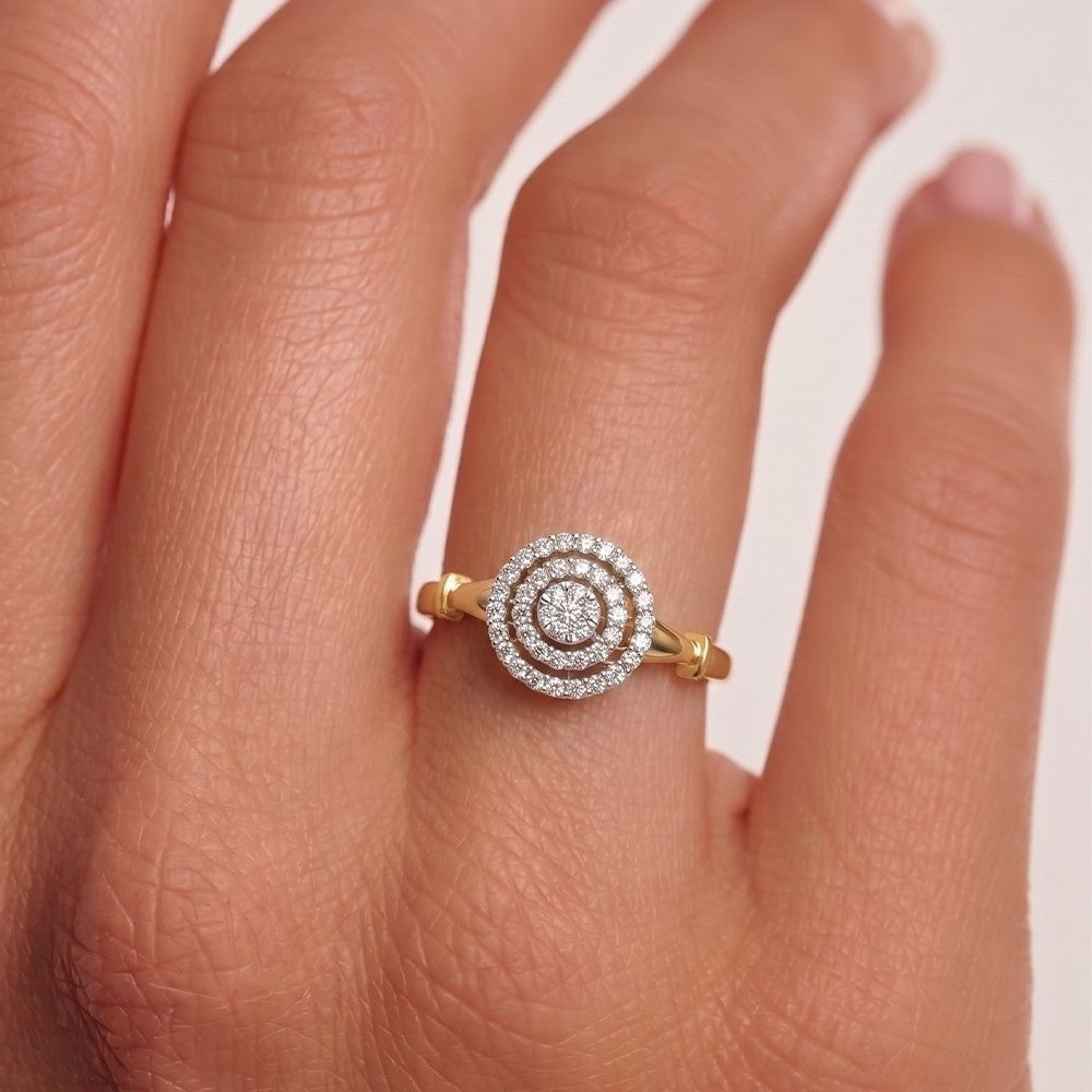 Gold and diamond ring on a person's finger with a white background