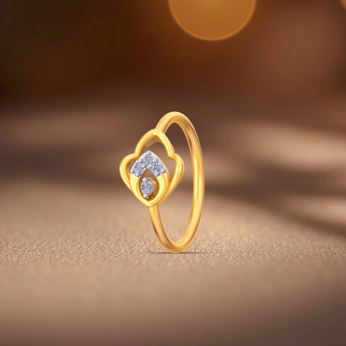 A gold and diamond ring with a floral design on a textured beige surface with a warm, blurred background.
