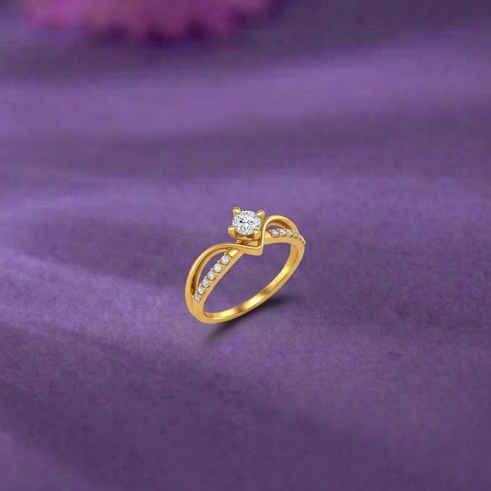 Gold ring with a diamond on a purple fabric background.