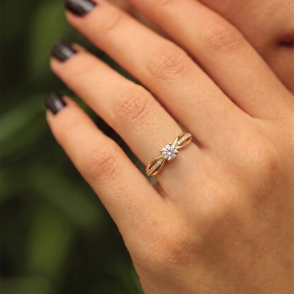 Close-up shot of gold ring with a diamond on a hand.