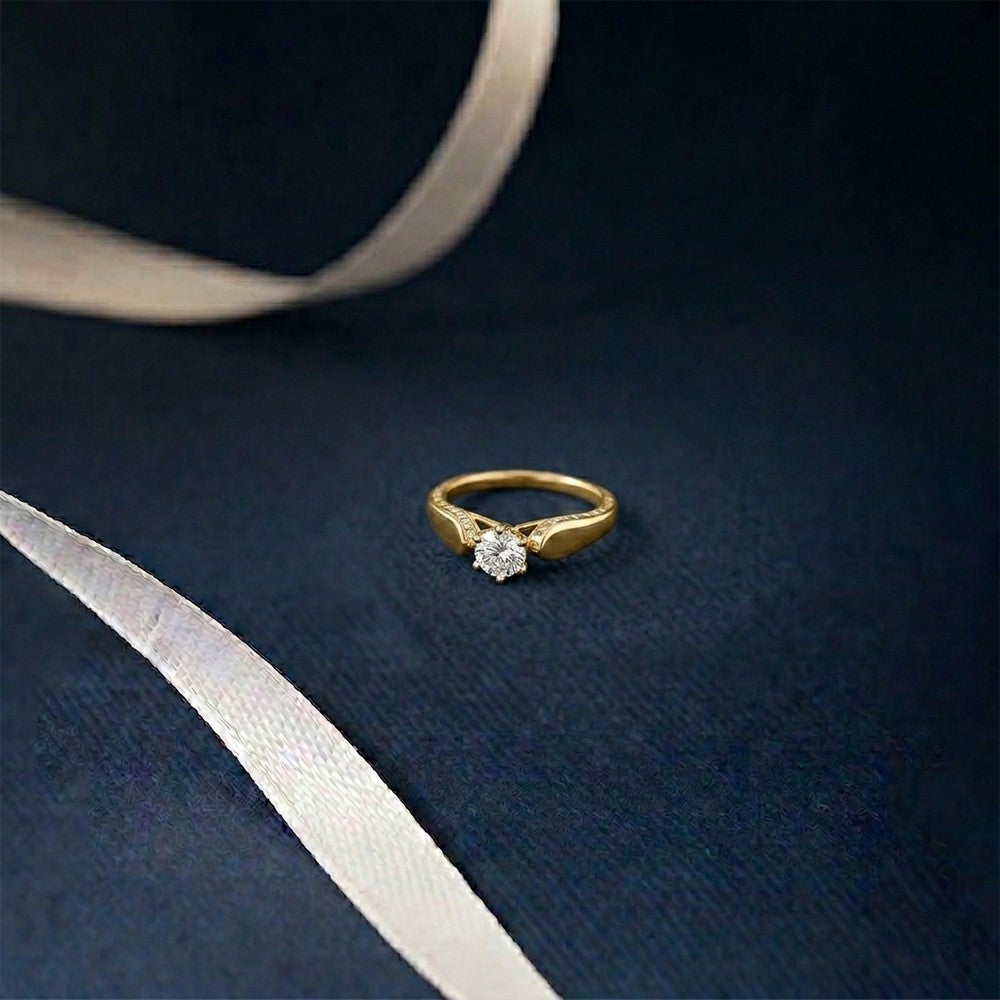 Gold ring with a diamond on a dark blue fabric background