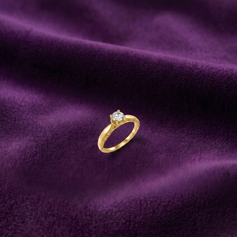 Gold ring with a diamond on a purple fabric background