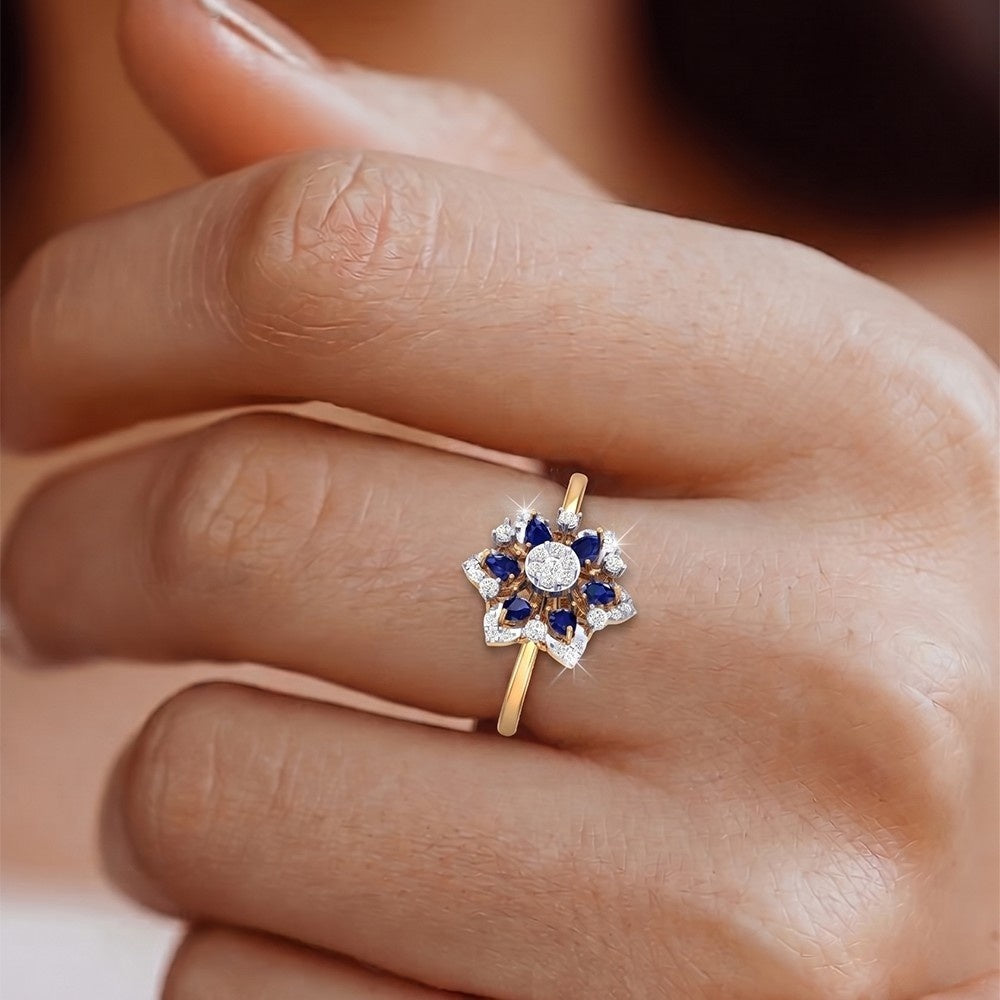 Gold ring with blue and white gemstones on a person's finger.