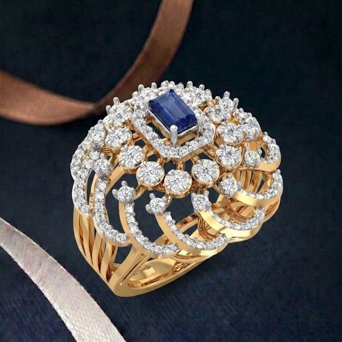 Gold and diamond with sapphire rectangular gemstone setting on a teal surface.