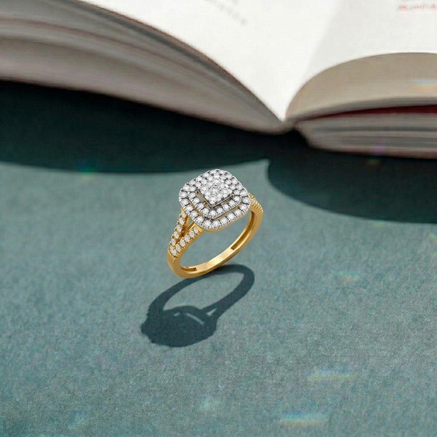 Gold ring with diamonds on a textured surface with an open book in the background