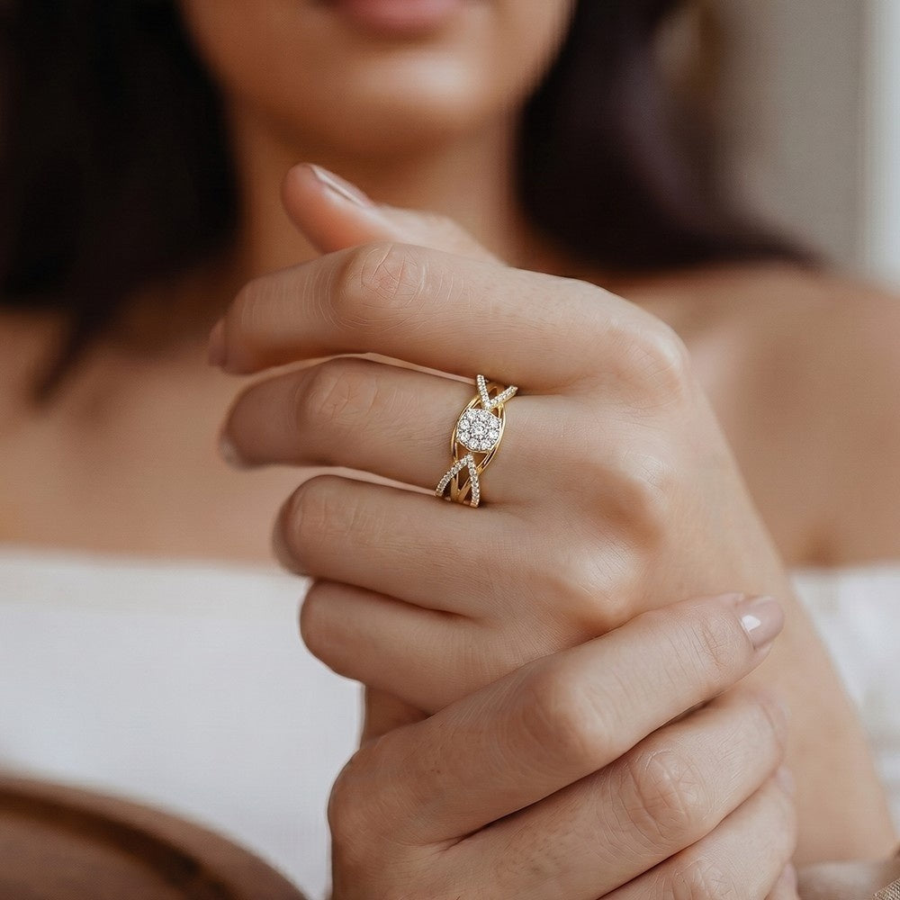 Close-up of a hand wearing a gold ring with a diamond, blurred background.