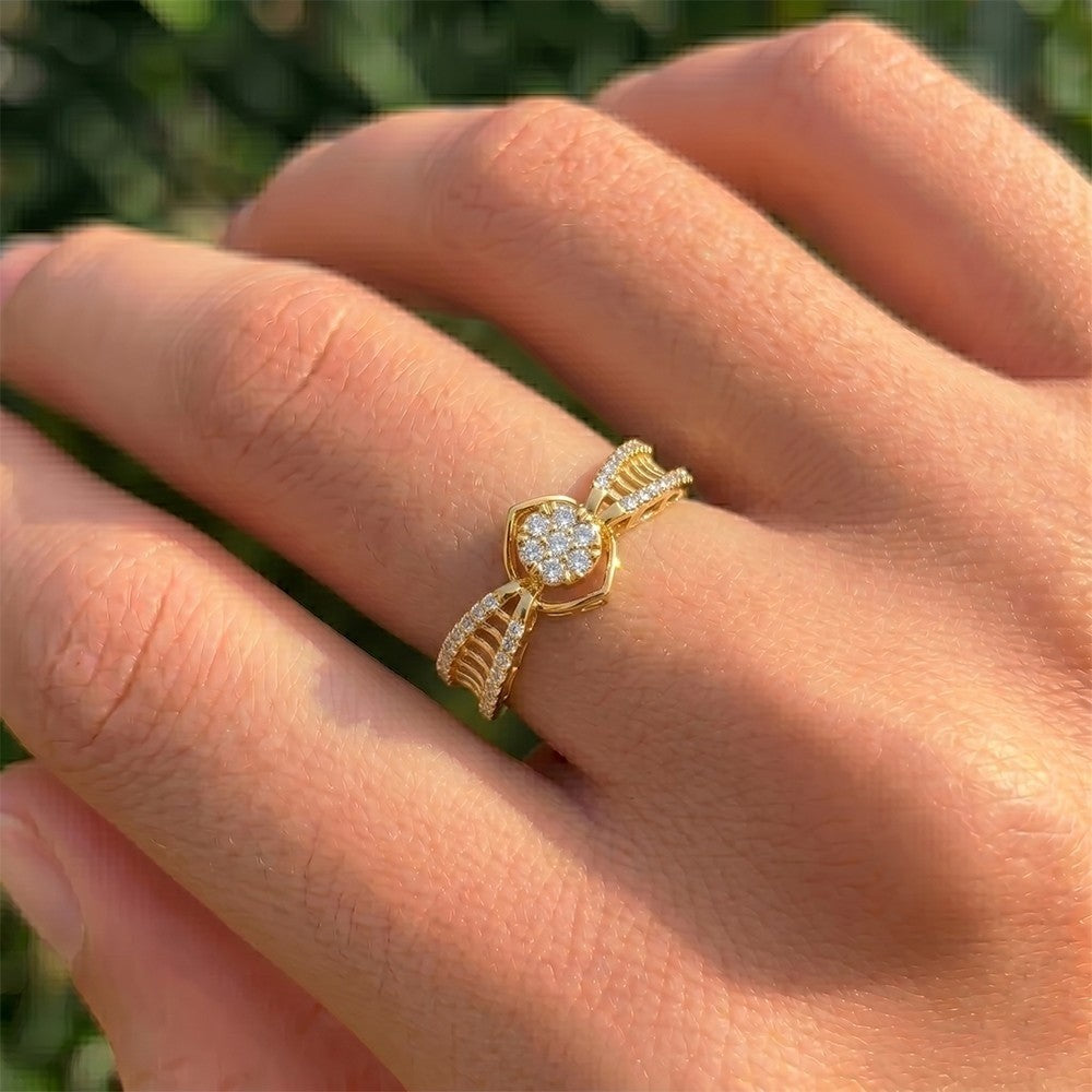 Gold ring with diamonds on a hand against a blurred green background