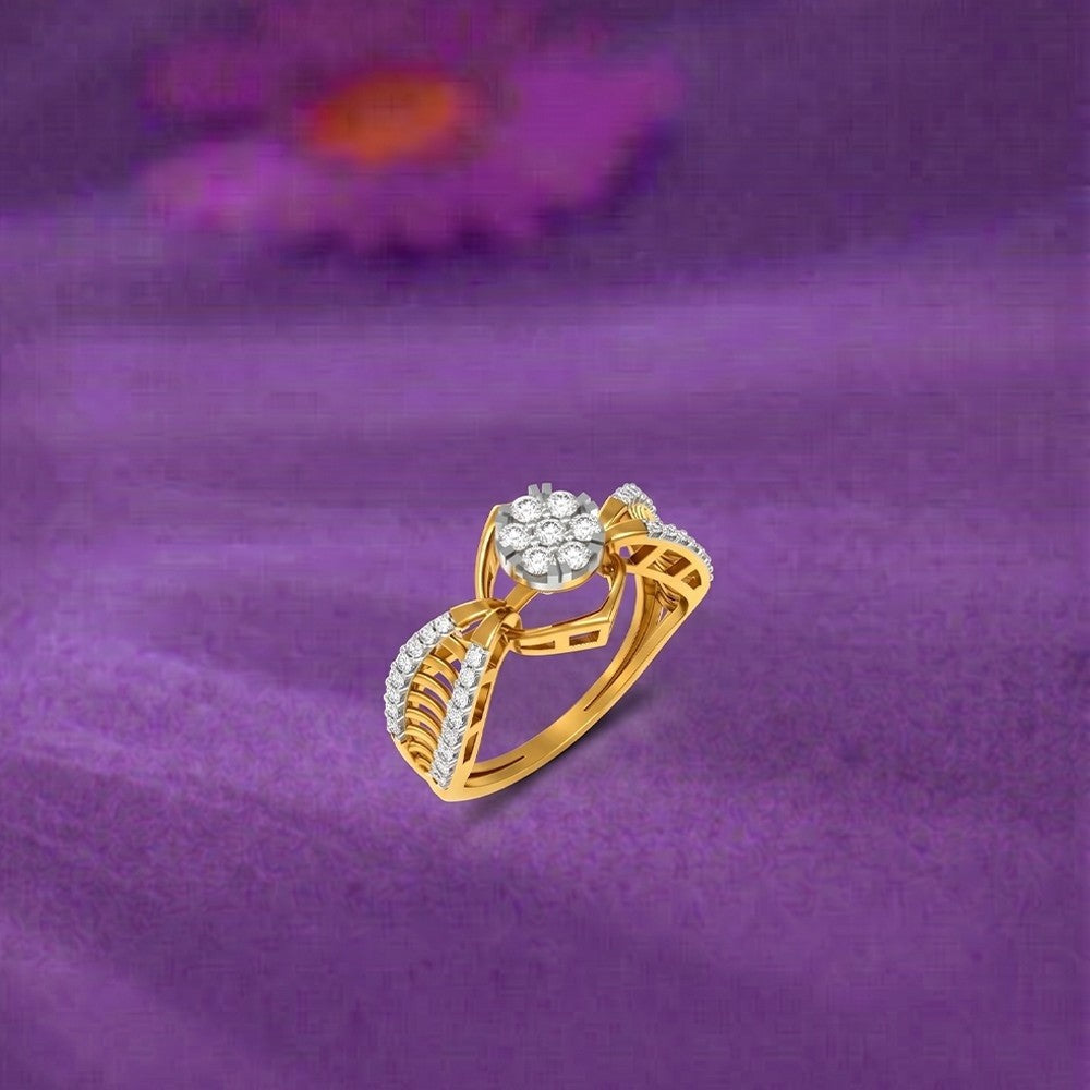 A gold ring with a cluster of clear stones, displayed on a textured purple fabric background.
