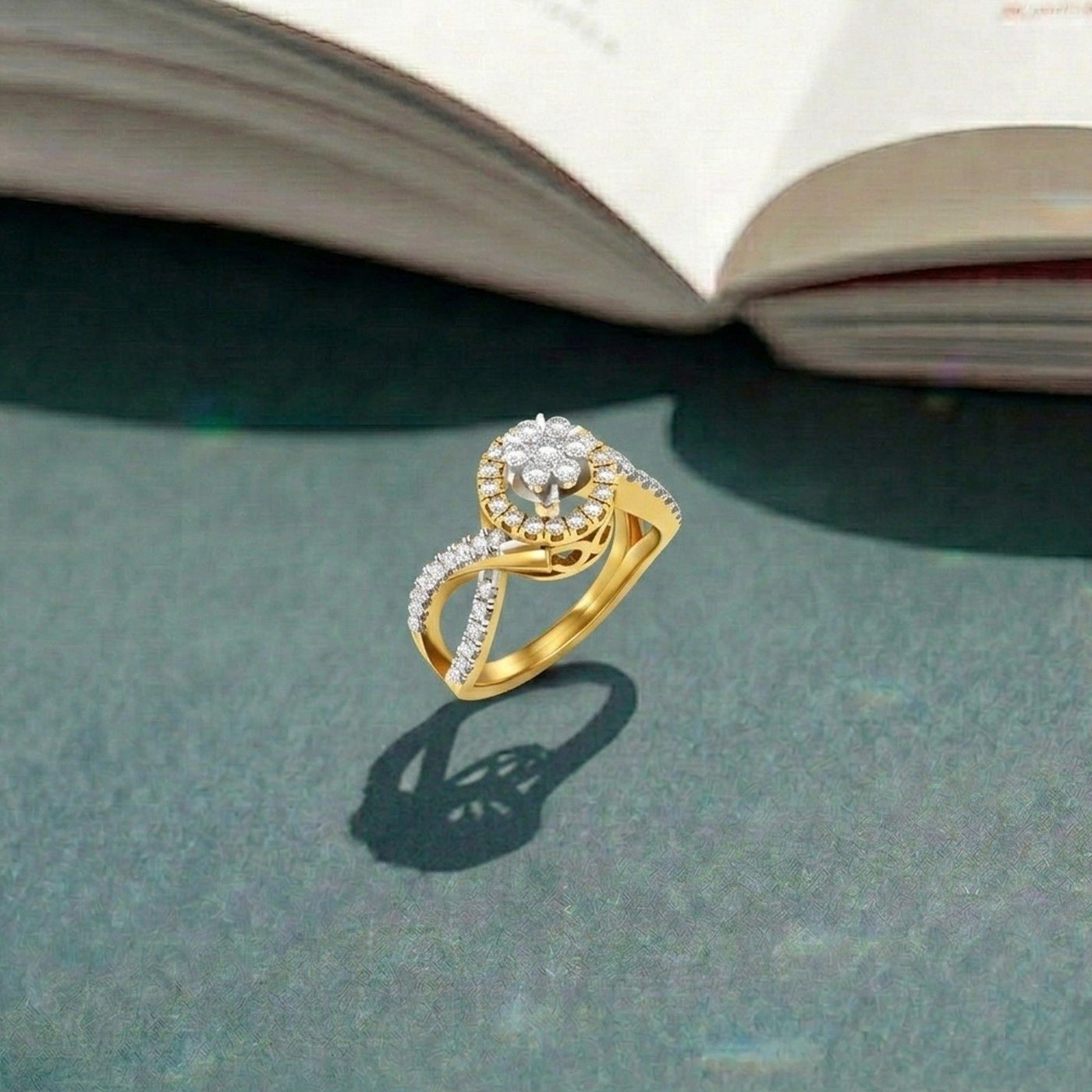 Gold ring with diamonds on a textured surface with an open book in the background.