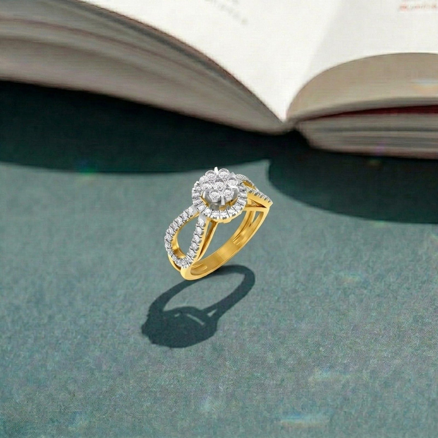 Gold ring with diamonds on a green surface with an open book in the background