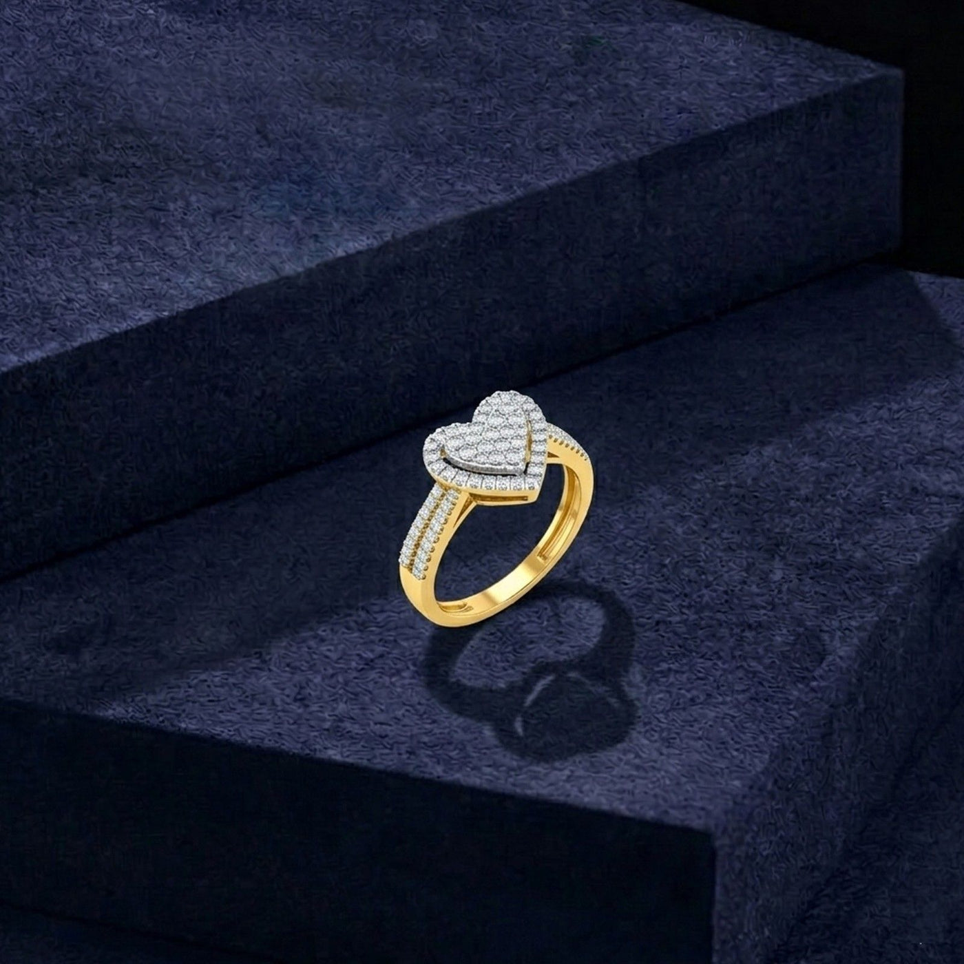 Gold and diamonds ring with heart-shaped on a dark blue textured surface.