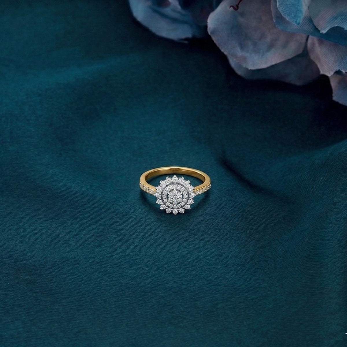 Gold ring with diamonds on a dark blue textured fabric background