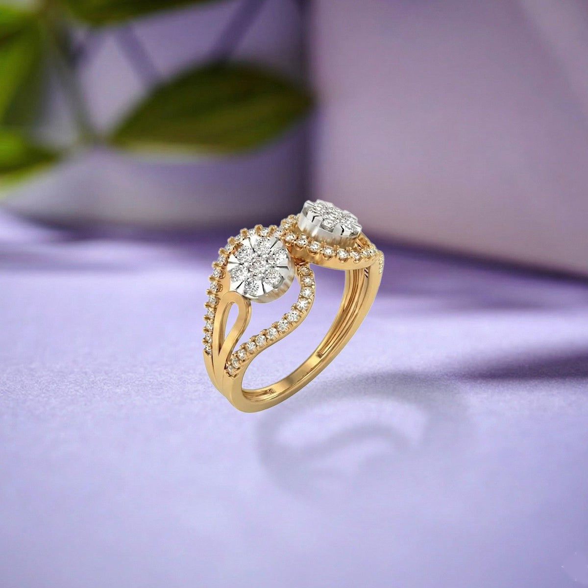 A gold ring with a round cluster design, resting on a dark purple fabric background.