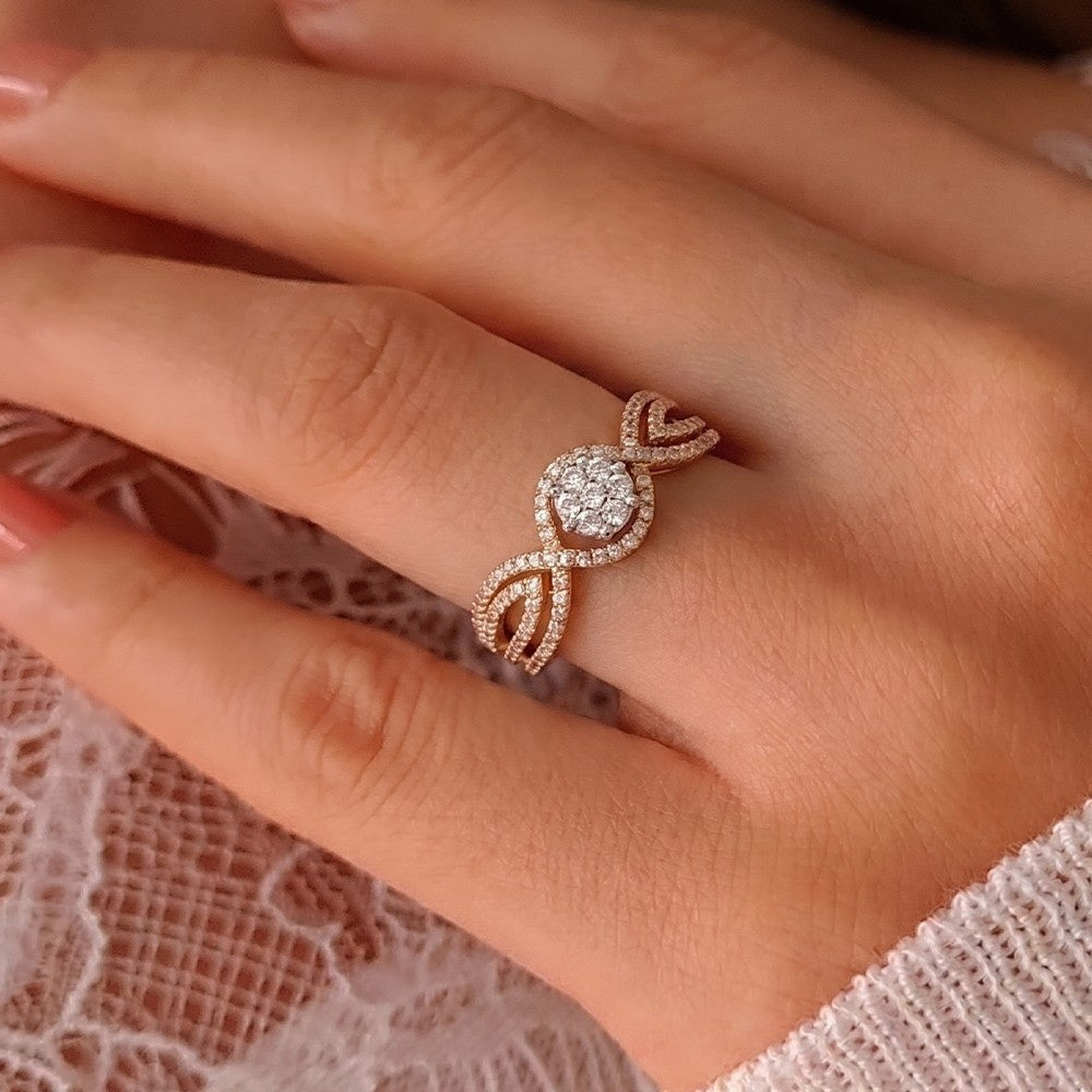 A close-up of a hand wearing a gold ring with a central round-cut ring.