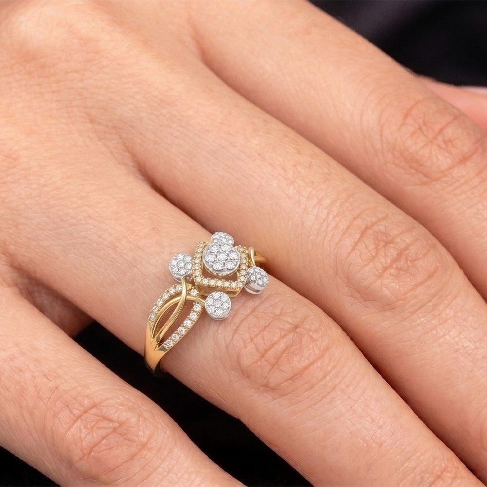 Gold and diamond ring on a person's finger against a neutral background
