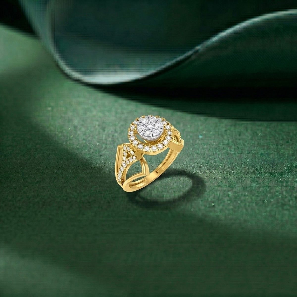 A gold ring with a round diamond center and a halo design, displayed on a textured dark green surface.