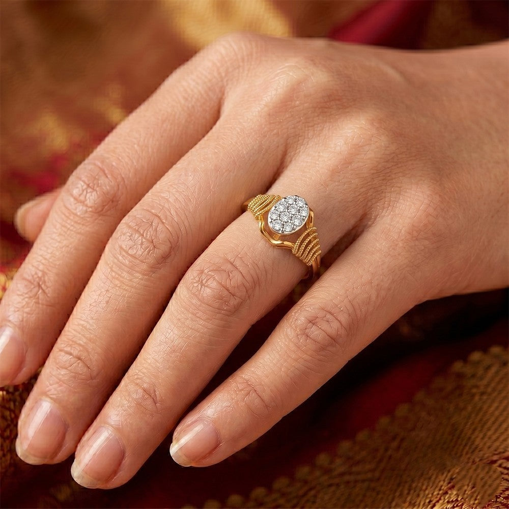 Close-up of a hand wearing a gold ring with diamonds on a textured fabric background.