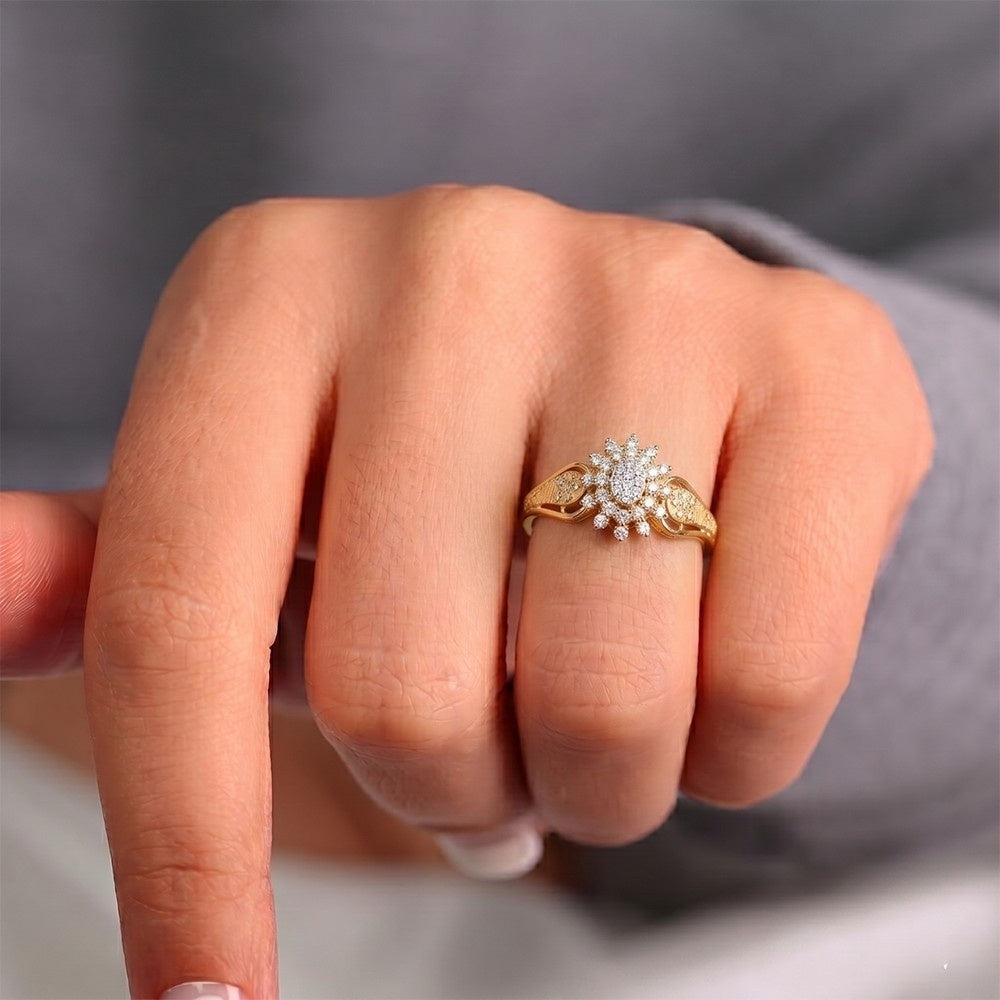 Gold ring with a diamond on a person's finger against a neutral background.