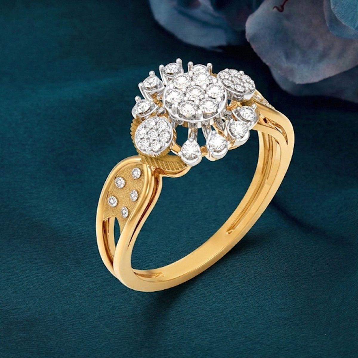 Gold ring with diamond cluster on a dark blue background.