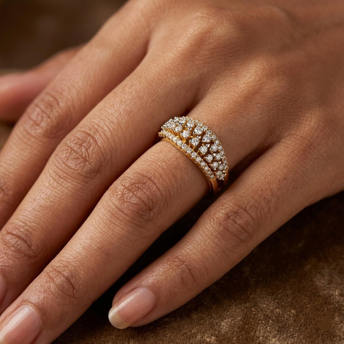 A close-up of a hand wearing a gold ring, blurred dark green background.