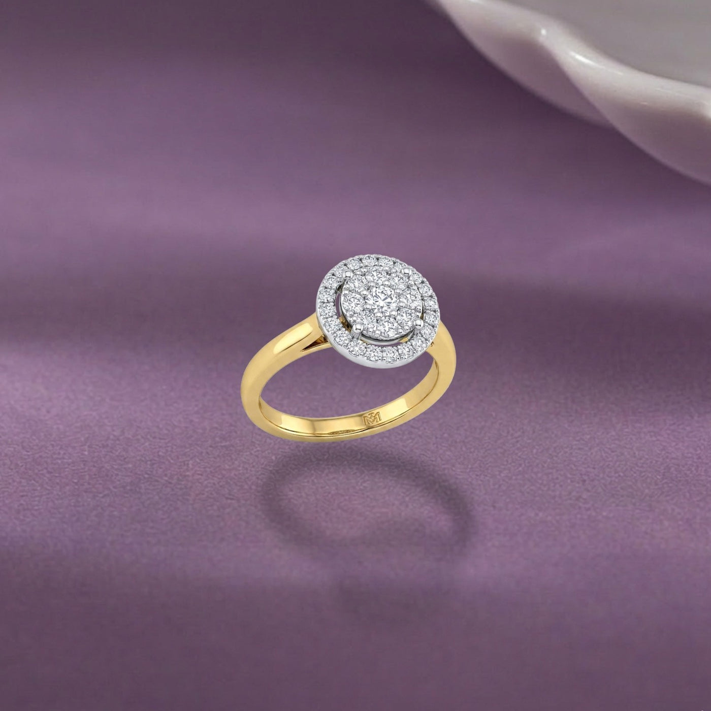 Gold ring with diamond accents on a purple fabric background