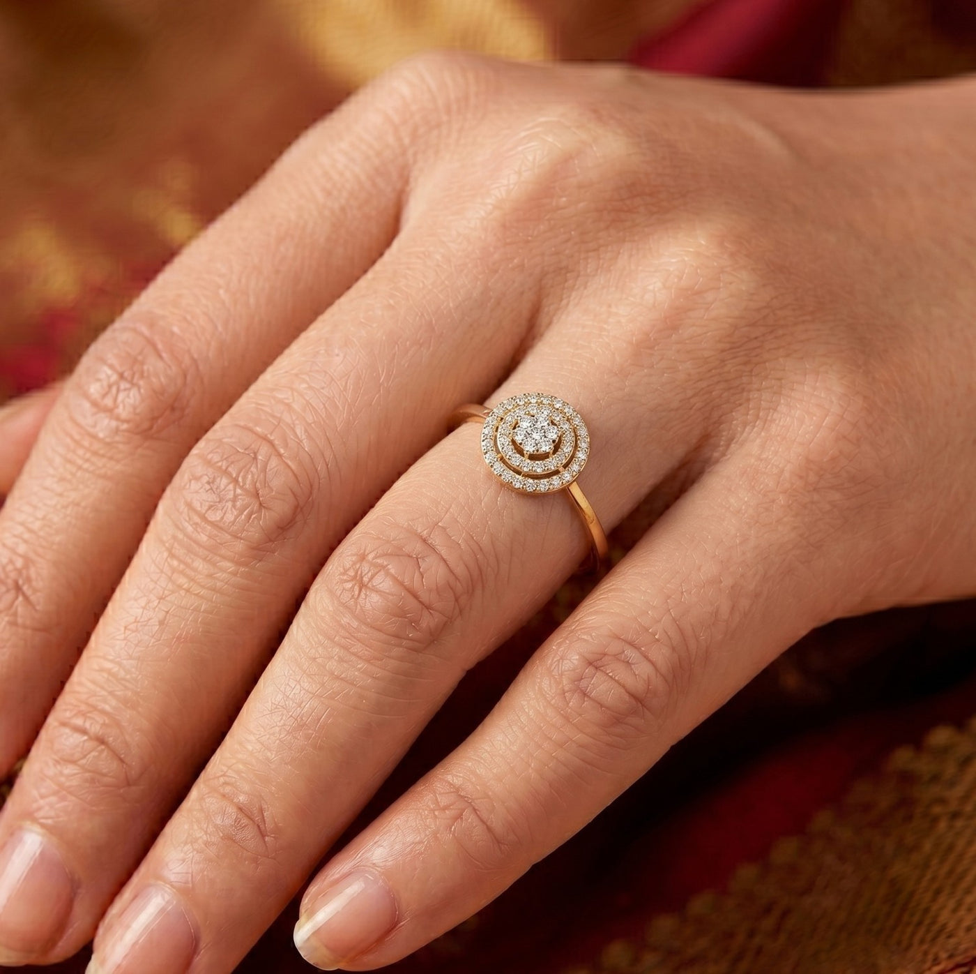 Close-up of a hand wearing a diamond ring with a blurred background