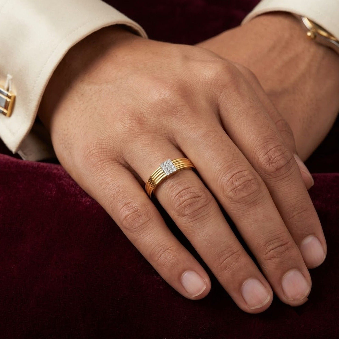 Gold ring with diamonds on a person's finger against a white background.