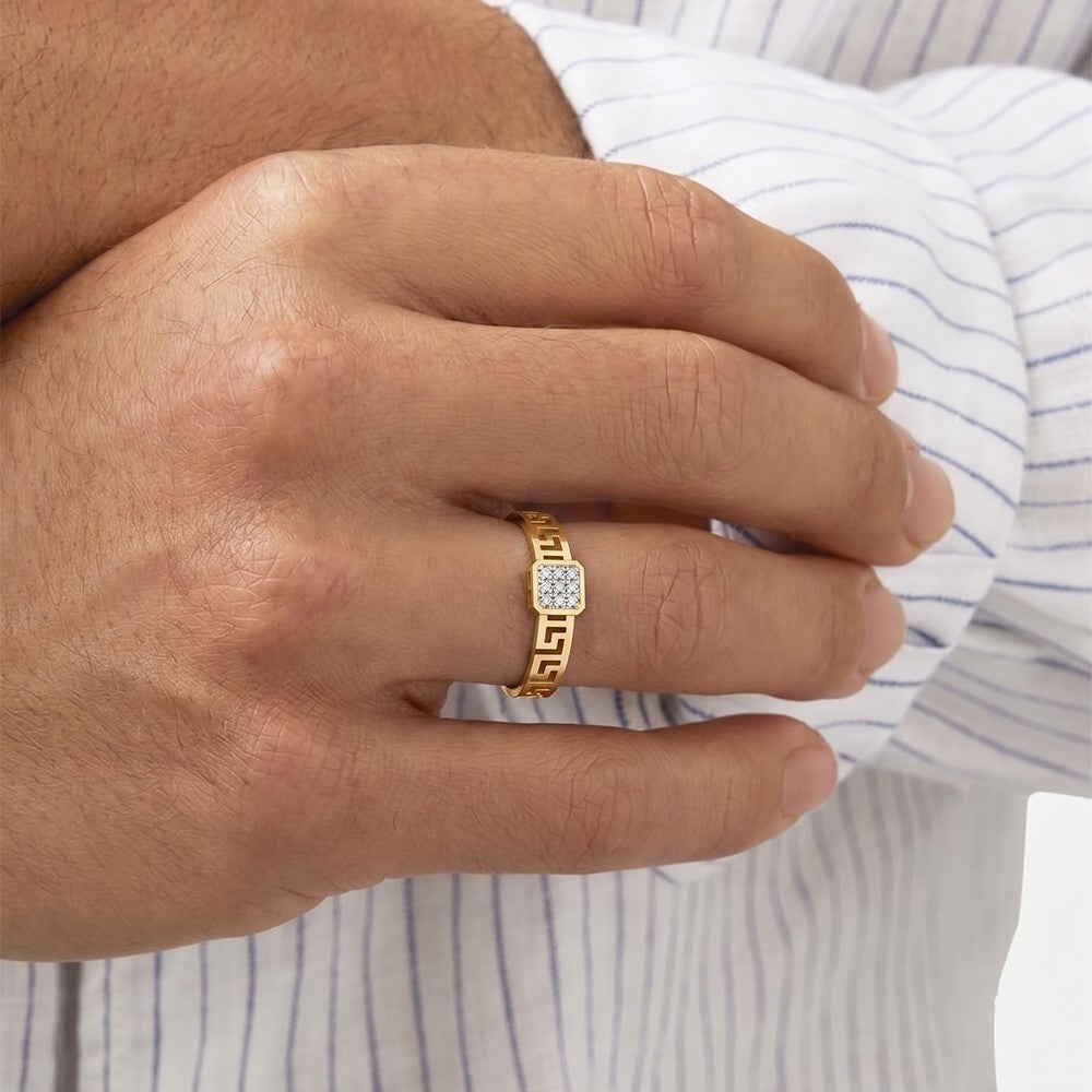 Hand wearing a gold ring with a diamond on a striped shirt background.