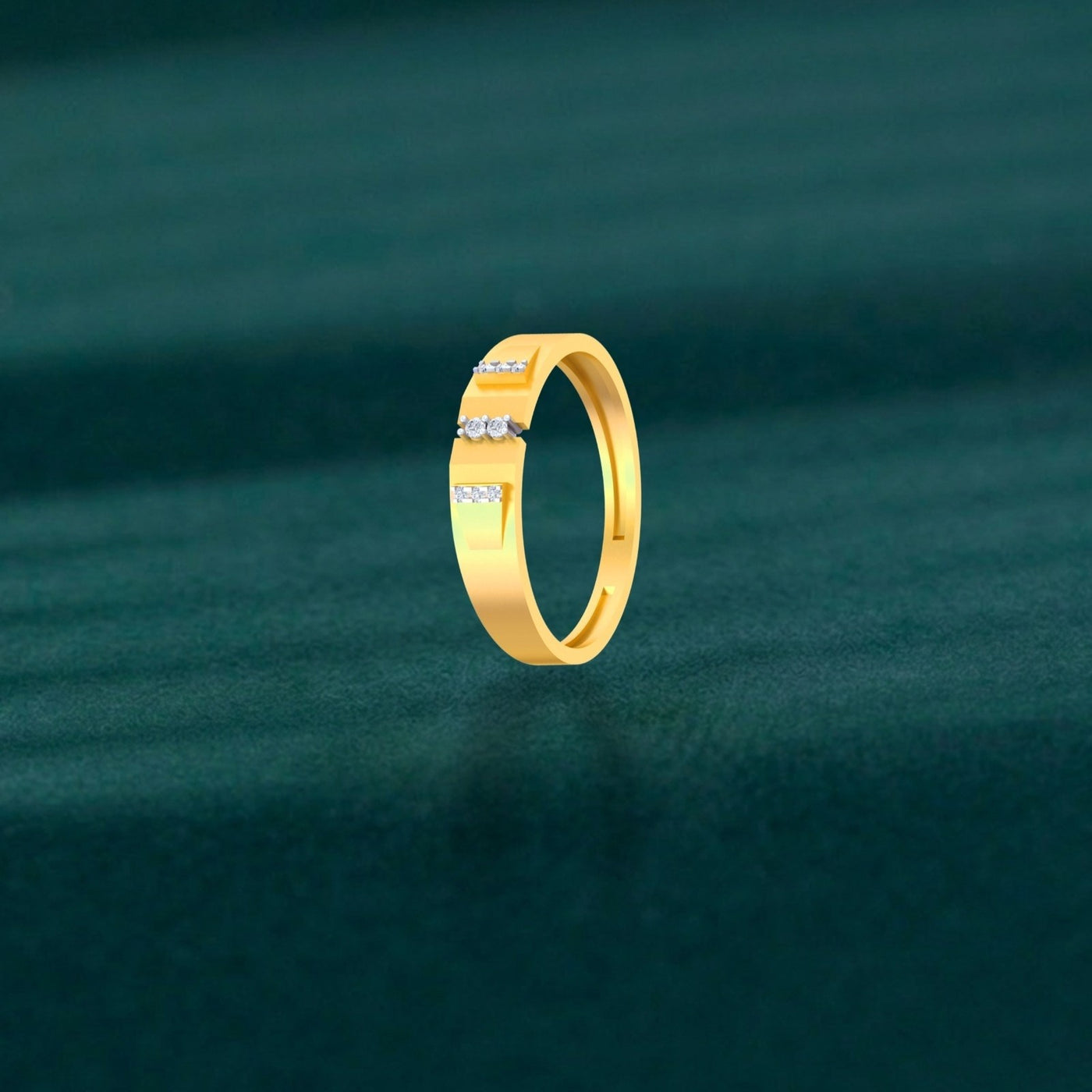 Gold band ring featuring  diamonds in the center, set against a plain teal background.