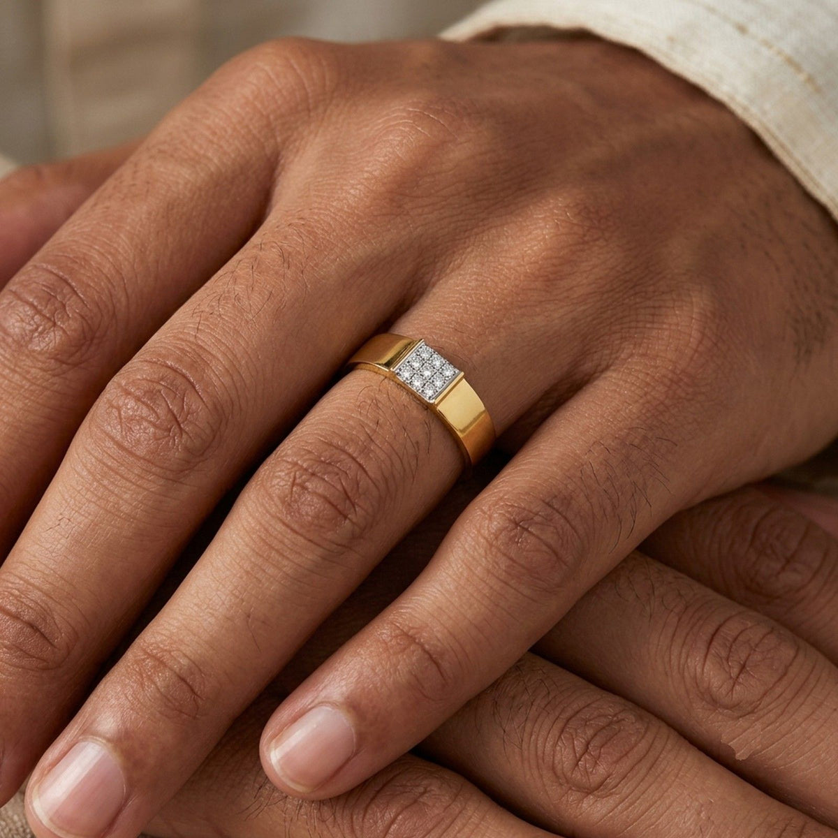 Close-up of a hand wearing a gold ring with a diamond, against a brown background.