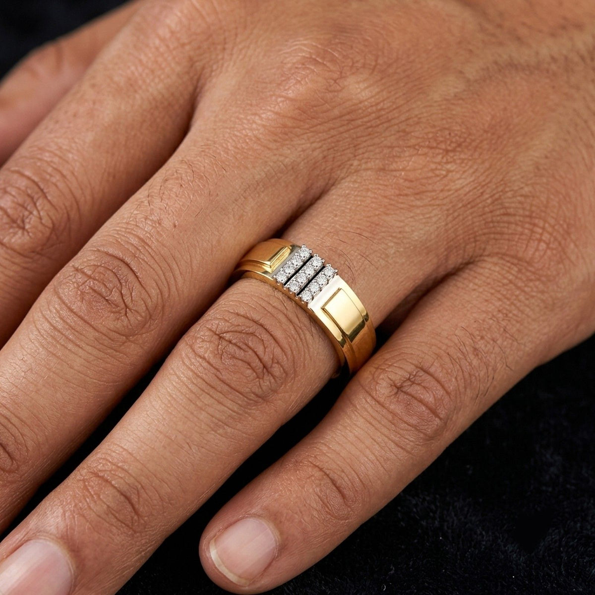 Hand wearing a gold ring with diamonds on a textured fabric background